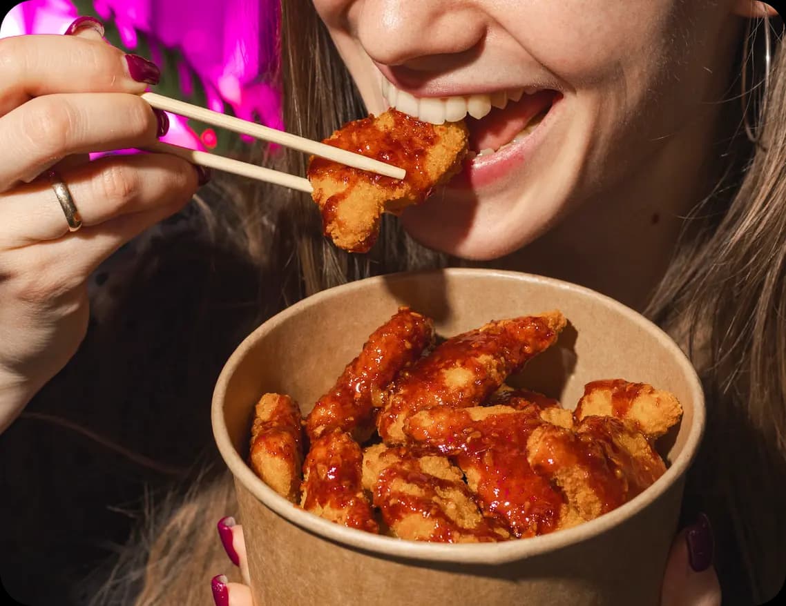 Kobieta jedząca Korean Fried Chicken w Solleim